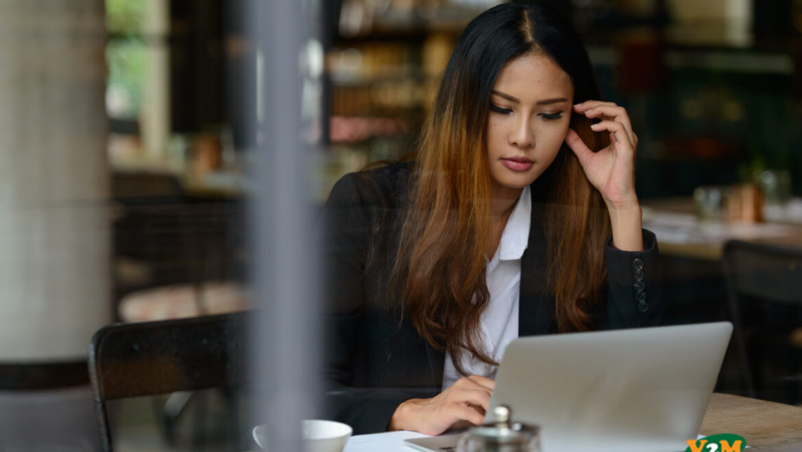 Young Woman using PC while working with customer in a restaurant